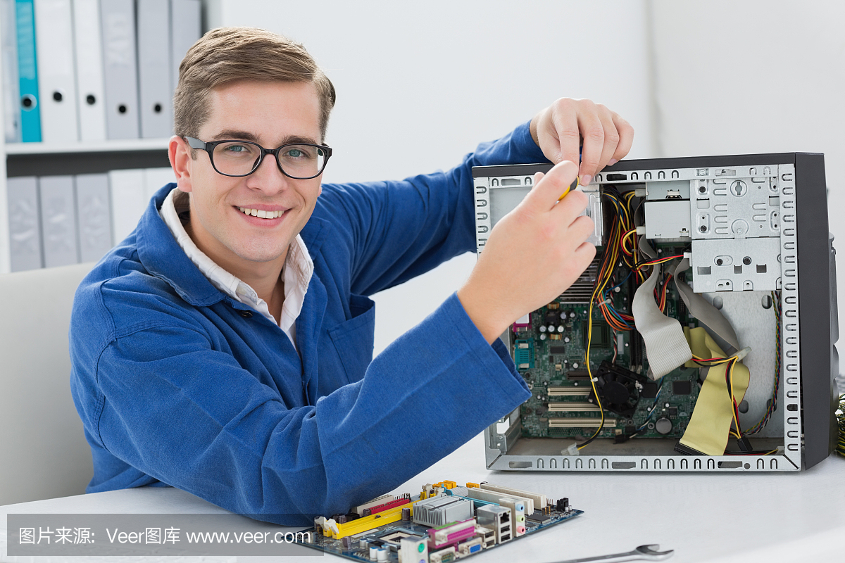 微笑的技術人員在損壞的電腦上工作